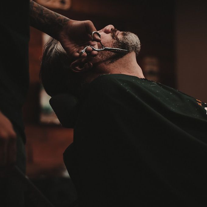 A beard being trimmed, scissors caught mid-cut