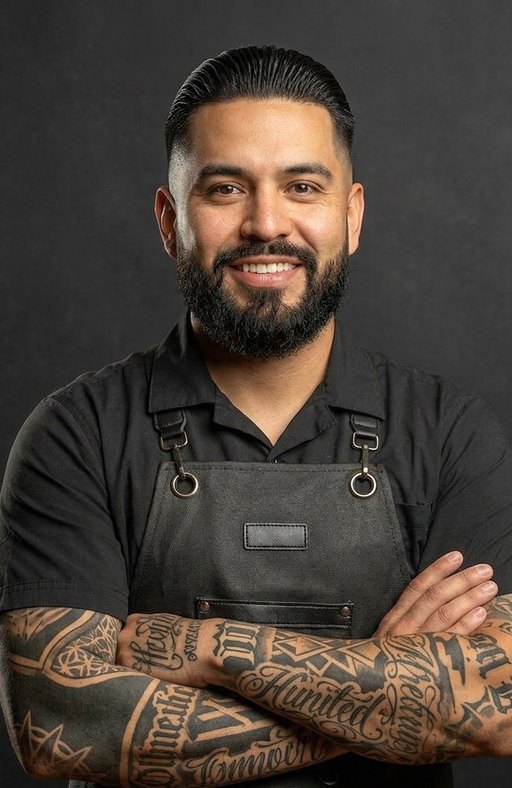 A barber with slicked-back hair and a full beard