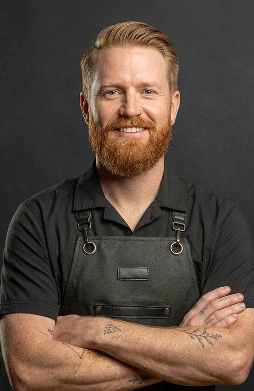 A barber with ginger hair and a full ginger beard